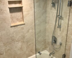 3/8” clear movable glass panel with chrome glass to wall hinges and bore thru back to back knob