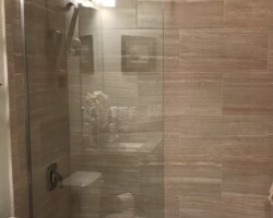 3/8” clear fixed panel glass with brushed nickel channel on 2 sides and horizontal support bar