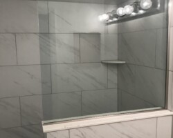 3/8” clear fixed panel glass with brushed nickel channel on 3 sides