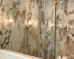 3/8” clear glass fixed panels with satin brass clamps