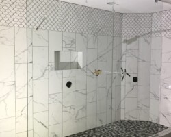1/2” clear glass fixed panels with chrome bottom channel and top clamps